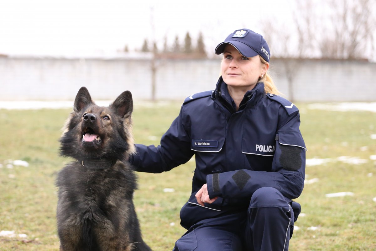Policjantka obok niej siedzi pies służbowy.