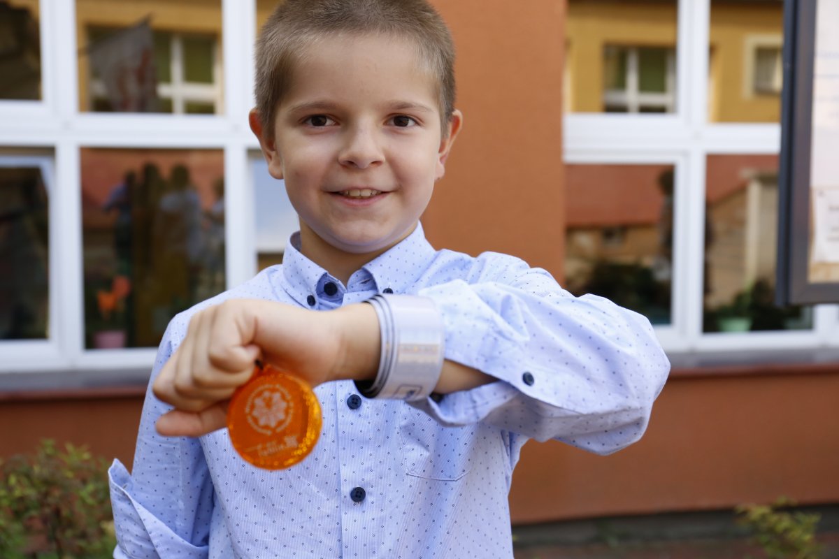 Chłopiec pokazuje odblaski umieszczone na dłoni.