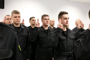 Grupa nowych policjantów wypowiadająca rotę ślubowania.