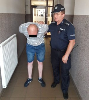policjant z zatrzymanym mężczyzną
