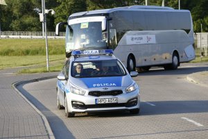 policyjny radiowóz eskortuje autokar z piłkarzami