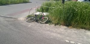 uszkodzony rower, leży na poboczu drogi