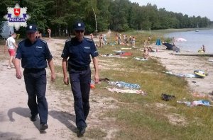 patrol nad wodą , policjanci idą wzdłuż plaży