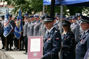 Komendant Wojewódzki Policji w Lublinie trzyma w ręku uznanie wręczone przez Wicewojewodę Lubelskiego