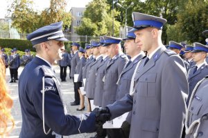 Komendant Wojewódzki Policji w Lublinie gratuluje wyróżnionemu funkcjonariuszowi podając prawą rękę.