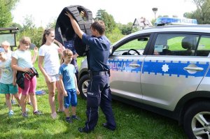 fot.: policjant pomaga przymierzyć dzieciom elementy umundurowania