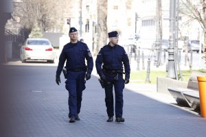 Dwóch policjantów umundurowanych patroluje ulicę.