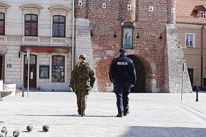 Funkcjonariusz policji oraz obrony terytorialnej patroluje Krakowskie Przedmieście w Lublinie.