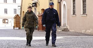 Funkcjonariusz policji oraz obrony terytorialnej patroluje Stare Miasto w Lublinie.