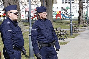 Dwóch policjantów w umundurowaniu patroluje ulice.