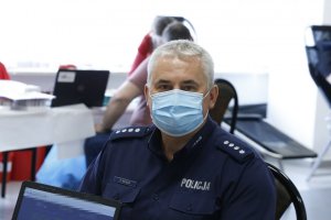 Komendant Miejski Policji w Lublinie z założona maseczką zakrywającą usta i nos czeka na badania do poboru krwi.
