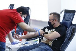 Funkcjonariusz po cywilnemu siedzi na fotelu obok niego pracownik Regionalnego Centrum Krwiodawstwa i Krwiolecznictwa w Lublinie pobiera krew.