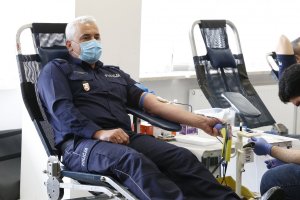 Komendant Miejski Policji siedzi na fotelu i oddaje krew.