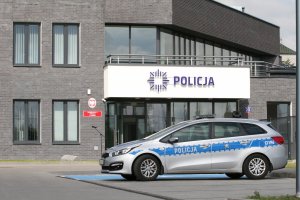 Oznakowany radiowóz policji w tle nowy budynek pierwszego komisariatu policji w Lublinie.
