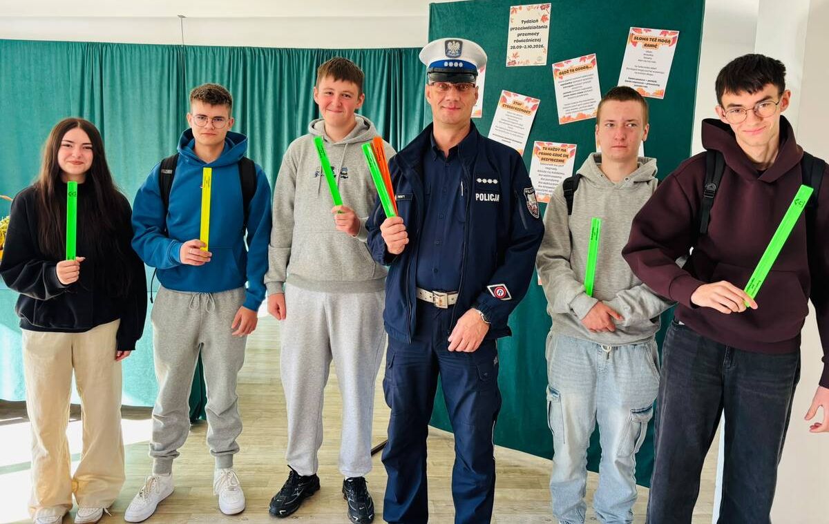 policjant z młodzieżą na spotkaniu, trzymają w ręku odblaski