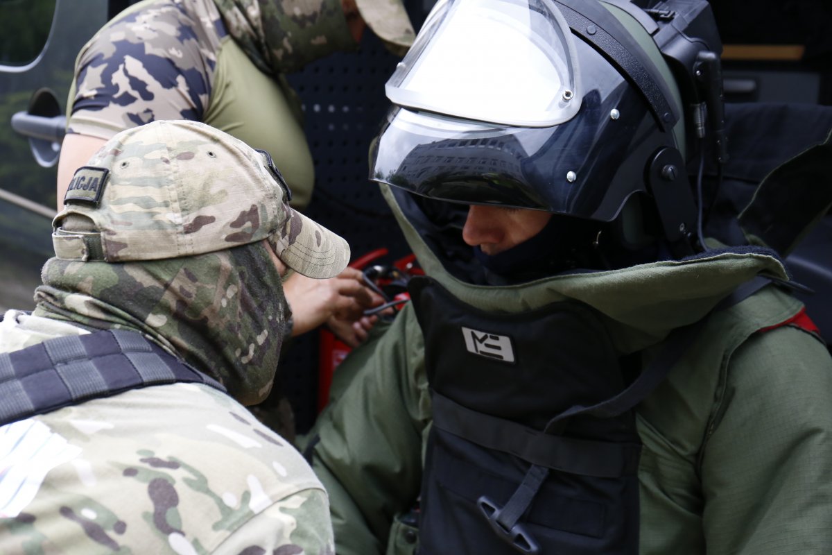 Policjanci z Samodzielnego Pododdziału Kontrterrorystycznego, jeden z nich ubrany w strój ochronny