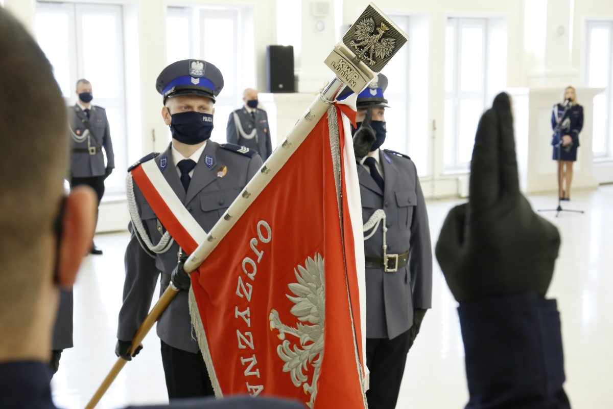 Policjant ślubuję na sztandar przed Pocztem Sztandarowym.