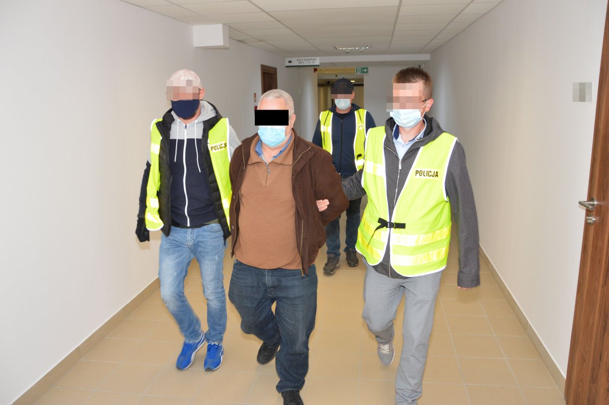 policjanci prowadzą zatzrymanego mężczyznę