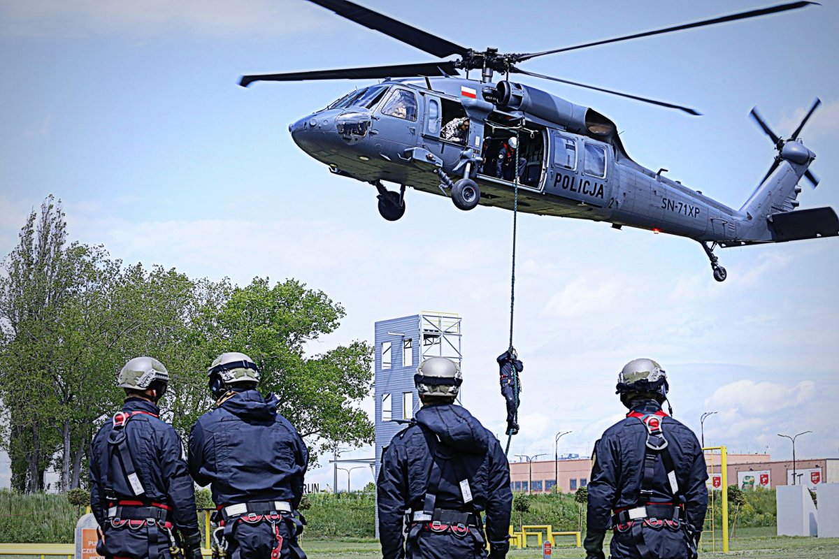 policyjny helikopter w powietrzu na dole policjanci podczas ćwiczeń