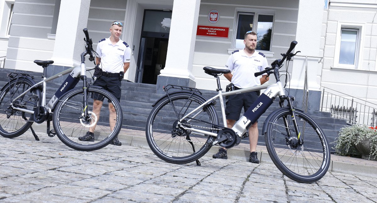 W pierwszym planie zdjęcia nowe elektryczne rowery w drugim planie policjanci.