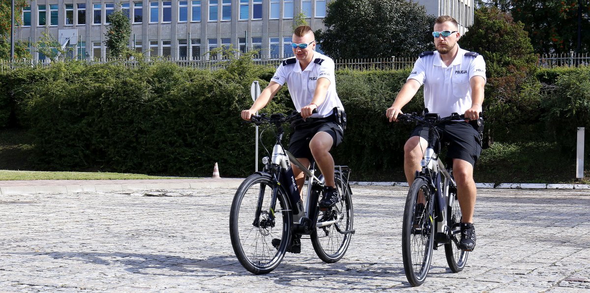 Policjanci jadą na rowerach elekrycznych. 