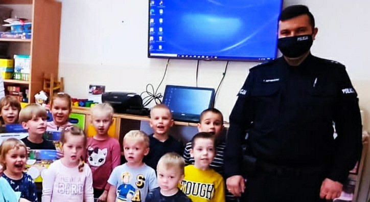 Zdjęcie przedstawia spotkanie dzielnicowego z dziećmi w szkole podstawowej w palecznicy na pierwszym planie dzieci w tle policjant.