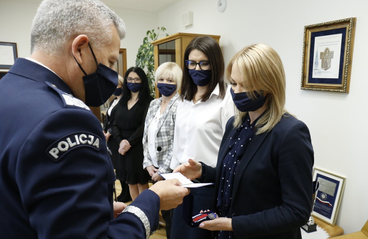 Komendant w swoim gabinecie wręcza odznaczenie pracownicy policji.