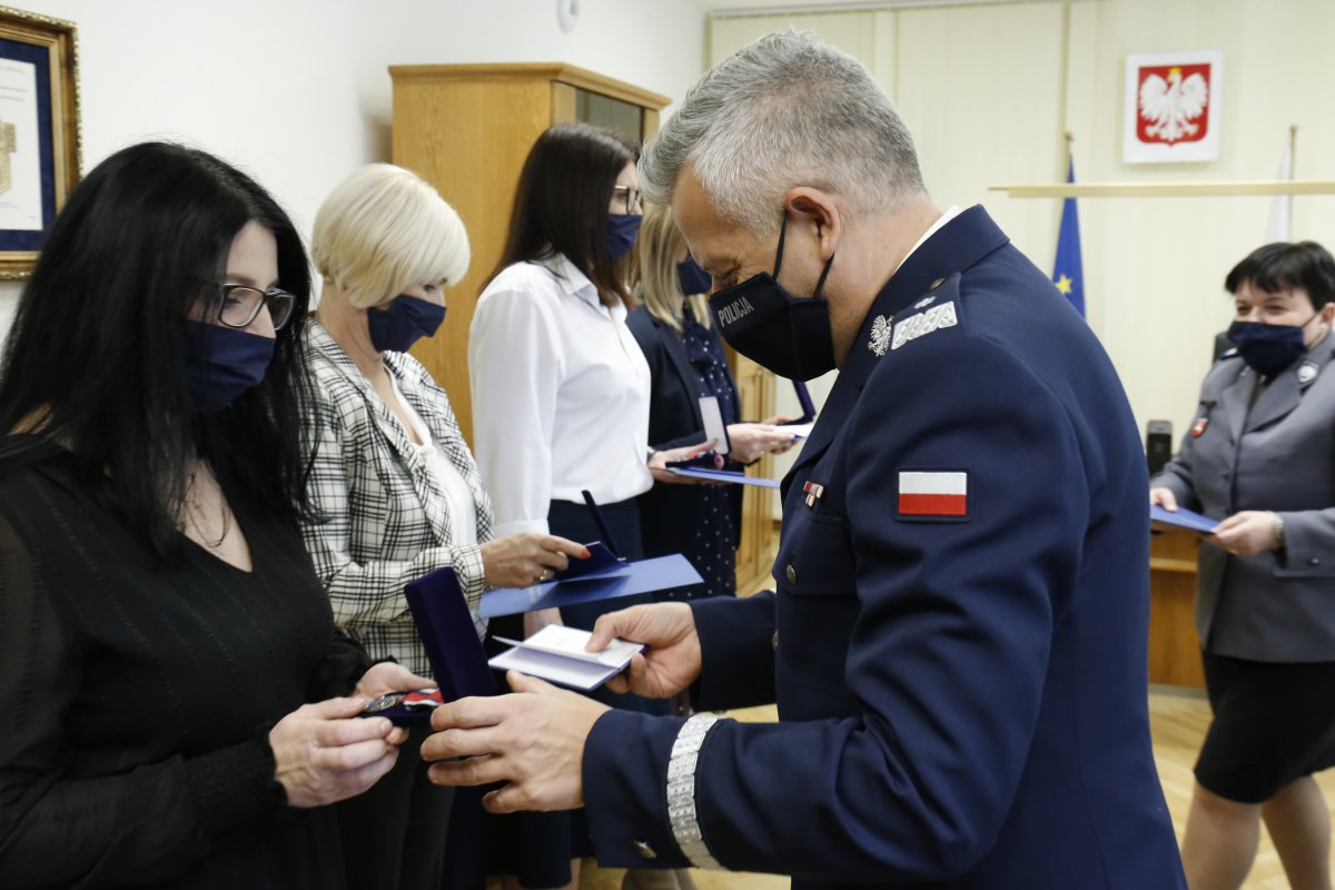 Komendant w swoim gabinecie wręcza odznaczenie pracownicy policji.