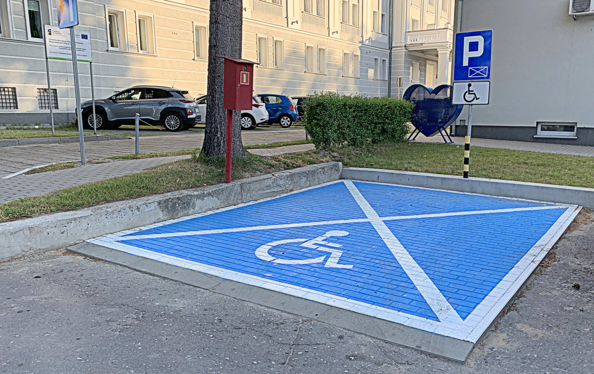Zdjęcie przedstawia miejsce parkingowe dla osób z niepełnosprawnością, które mogą zaparkować przy Komendzie Wojewódzkiej Policji w Lublinie.