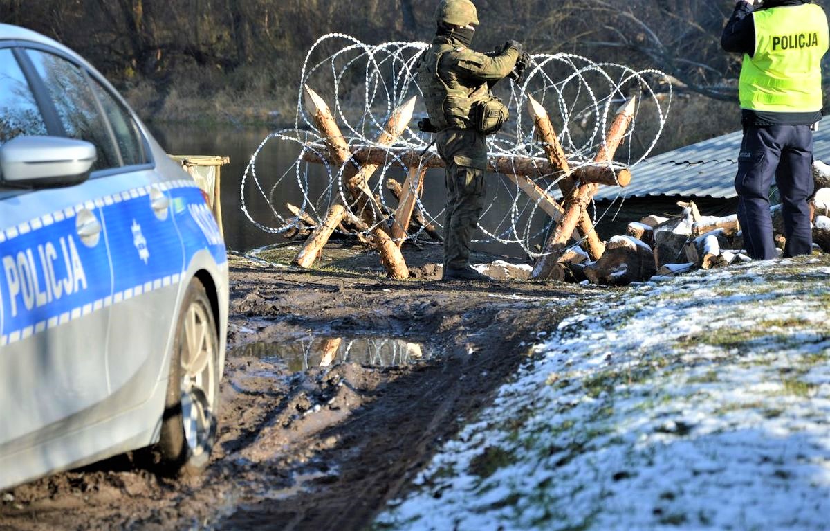 policjant i żołnierz przy rzece na granicy kraju