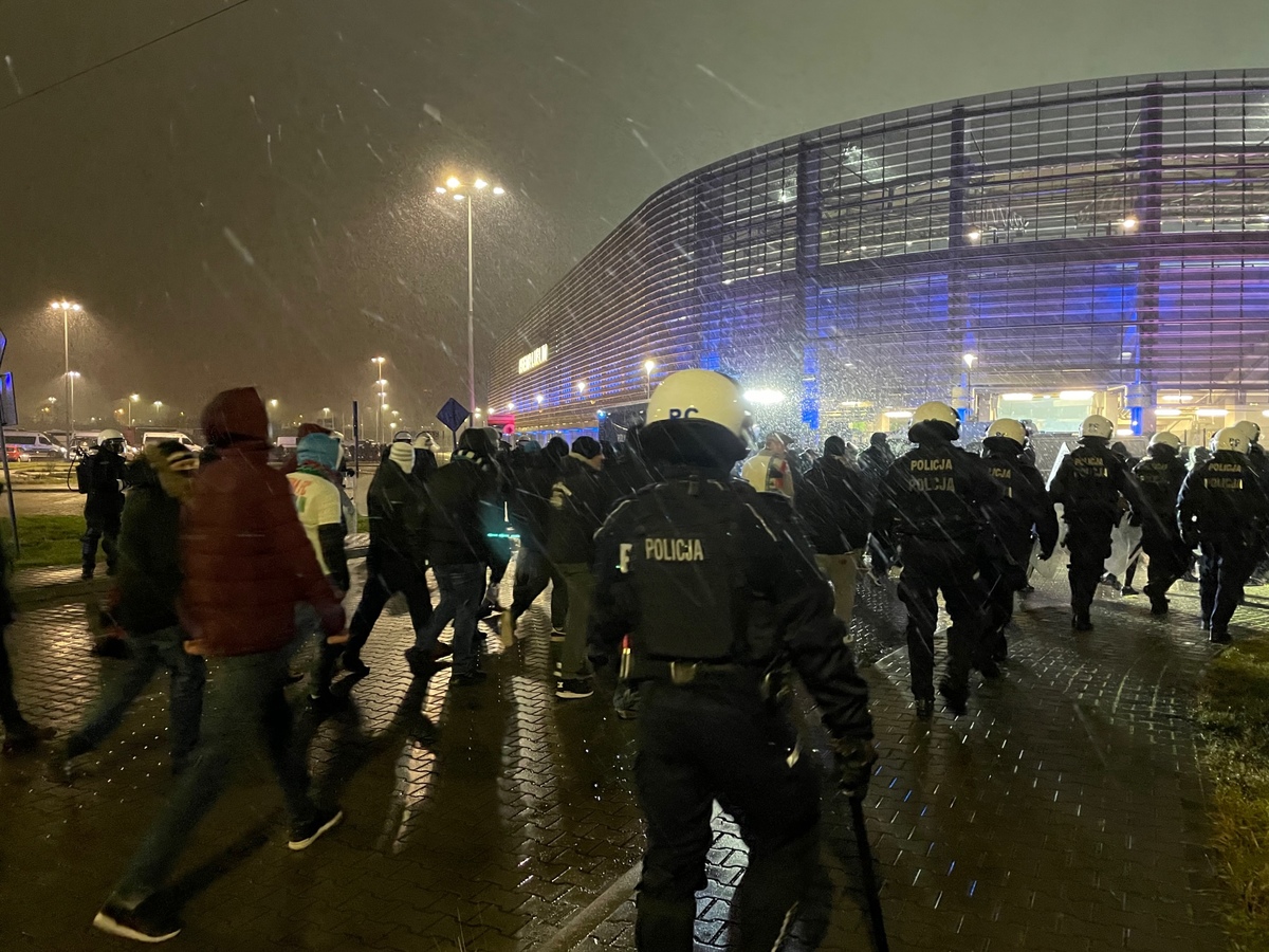 Zdjęcie wyonane przed stadionem Arena Lublin. Policjanci zabezpieczają mecz pilki nożnej.