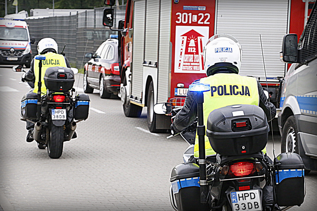 Policjaci jadą na motocyklach służbowych.