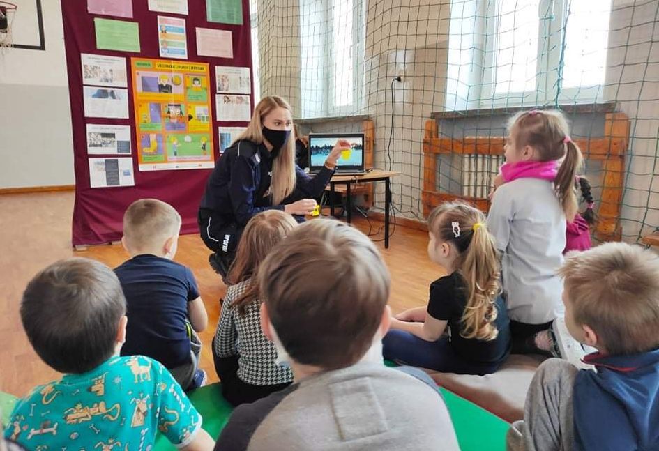 policjantka wreczajaca odblaski dla przedszkolaków