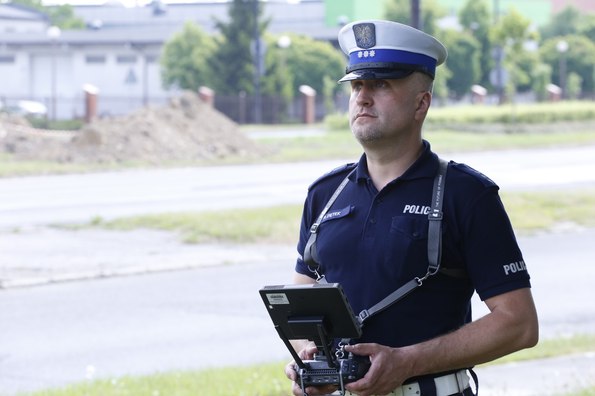 Zdjęcie przedstawia funkcjonariusza Ruchu Drogowego stertującego dronem.