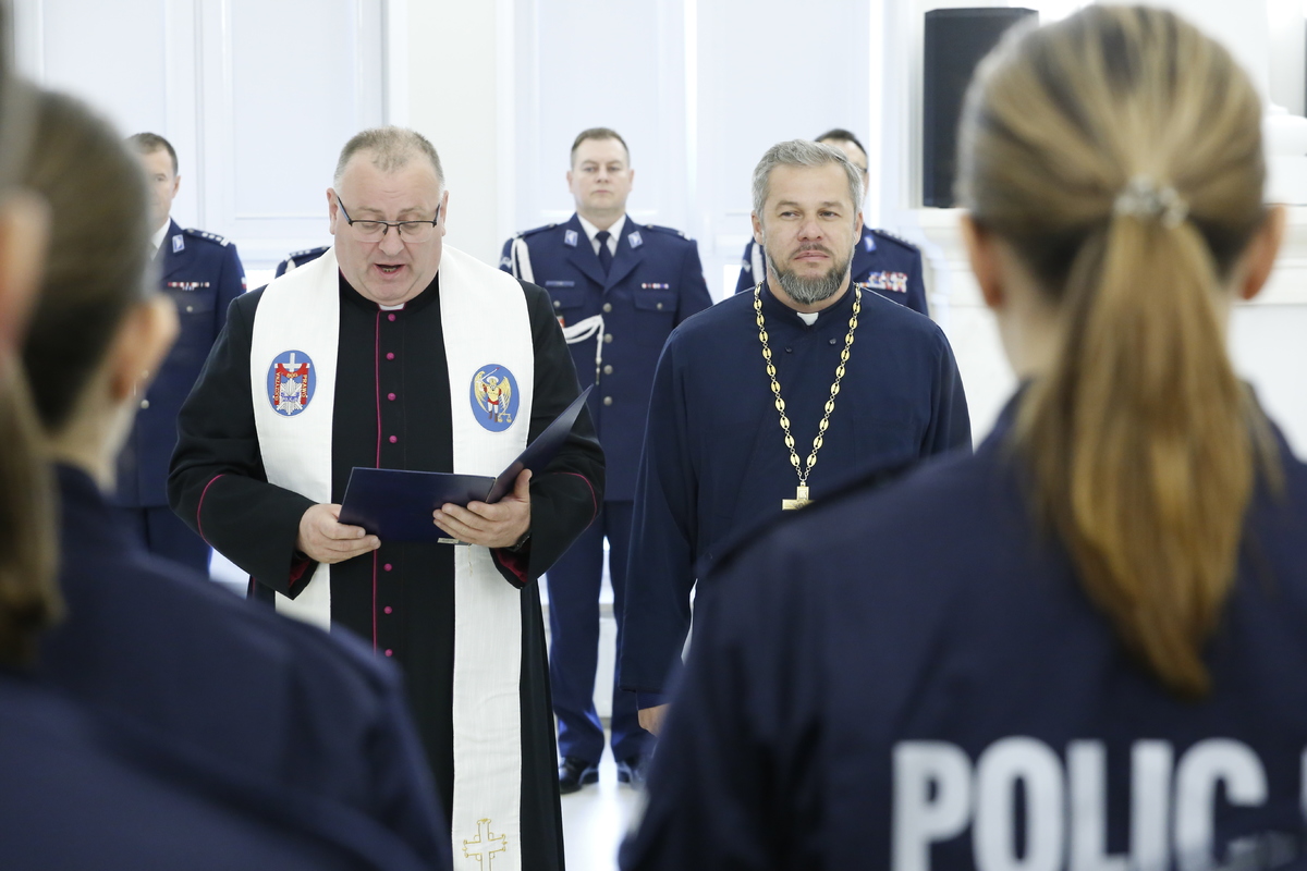 Kapelani Lubelskiej Policji ks. Bogdan Zagórski oraz ks. Macin Gościk błogosławią nowych funkcjonariuszy.