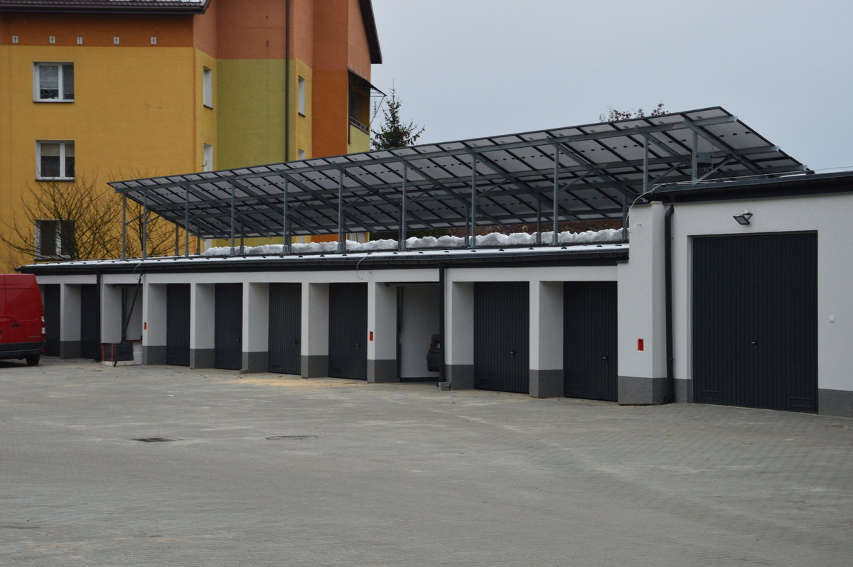 Garaże dla pojazdów służbowych z zamontowanymi panelami słonecznymi na dachu.