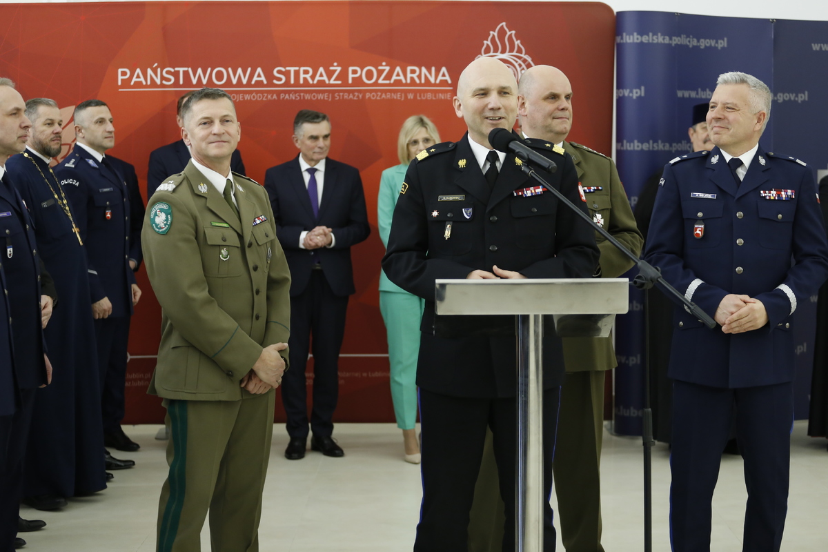Zdjęcie przedstawia spotkanie przedświąteczne służb mundurowych. W pierwszym planie zdjęcia widzimy przemawiającego do zgromadzonych gości Komendanta Państwowej Straży Pożarnej w Lublinie nadbrygadiera Grzegorza Alinowskiego.