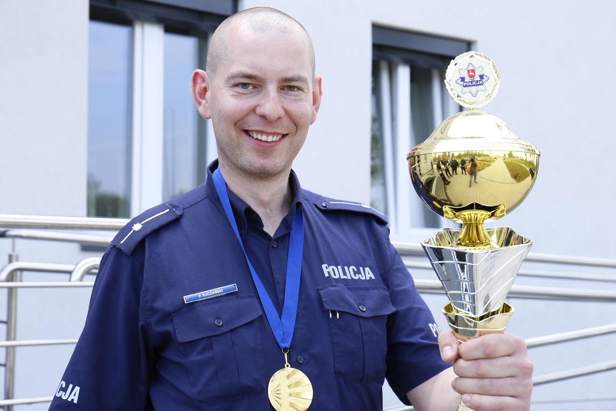 Funkcjonariusz z Komendy Powiatowej Policji w Rykach mł. asp. Piotr Koczański z pucharem za zajęcie pierwszego miejsca w Konkursie Policjant Ruchu Drogowego.