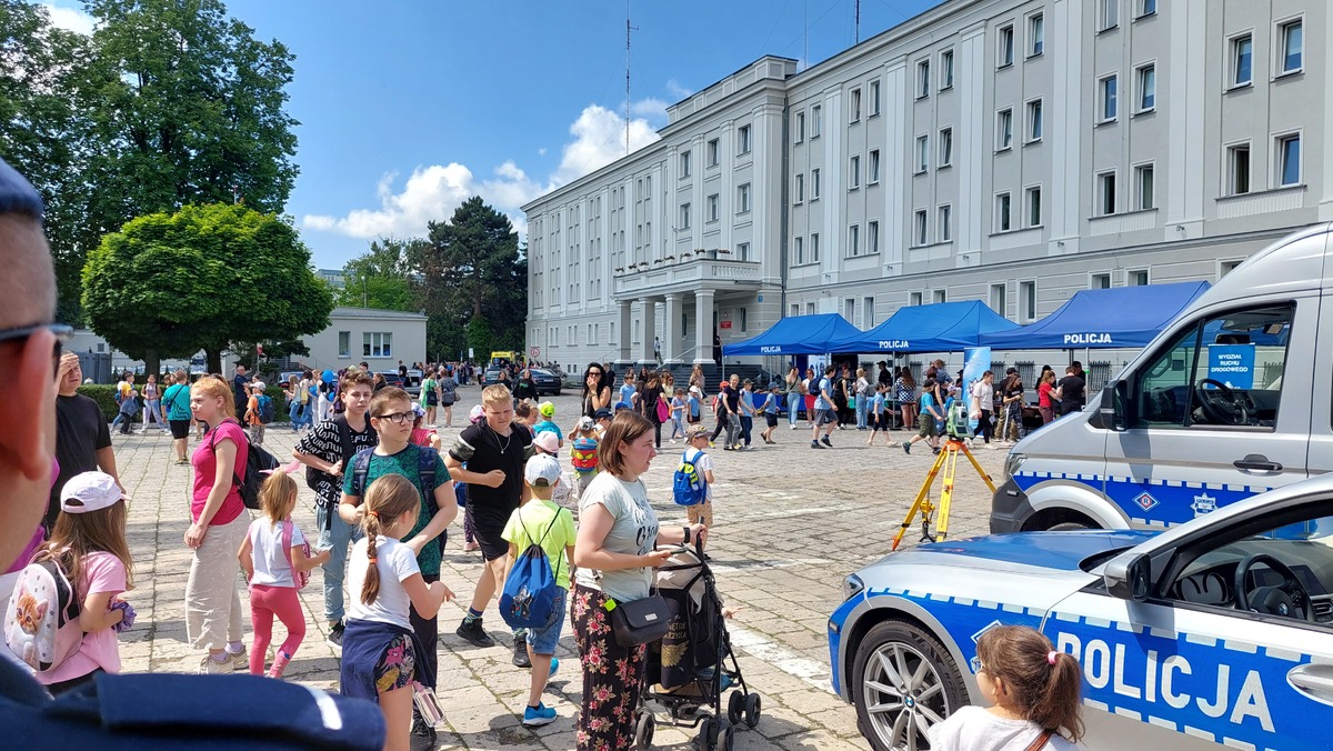 Na zdjęciu widzimy młodzież, która ogląda policyjne wyposażenie. W drugim planie zdjęcia Komenda Wojewódzka Policji w Lublinie.