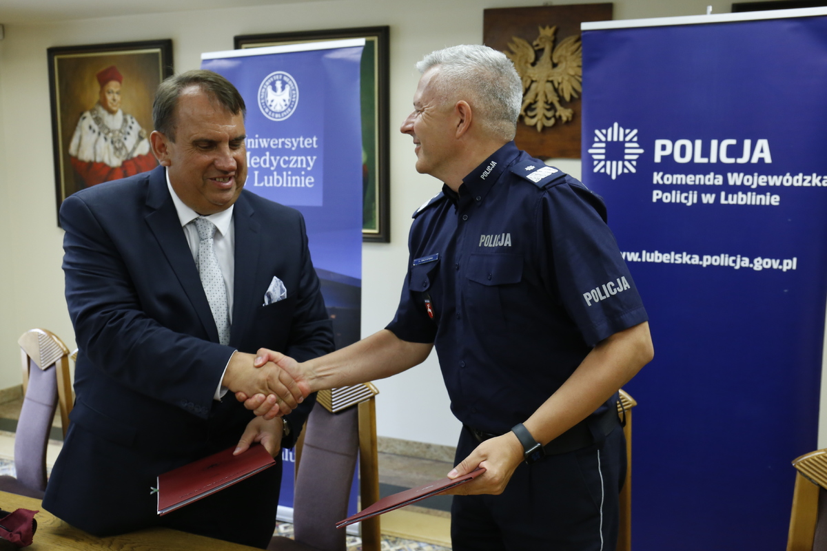 Komendant Wojewódzki Policji w Lublinie nadinsp. Artur Bielecki oraz profesor doktor habilitowany n.med. Wojciech Załuska Rektor Uniwersytetu Medycznego w Lublinie podają sobie dłoń pieczętując porozumienie.