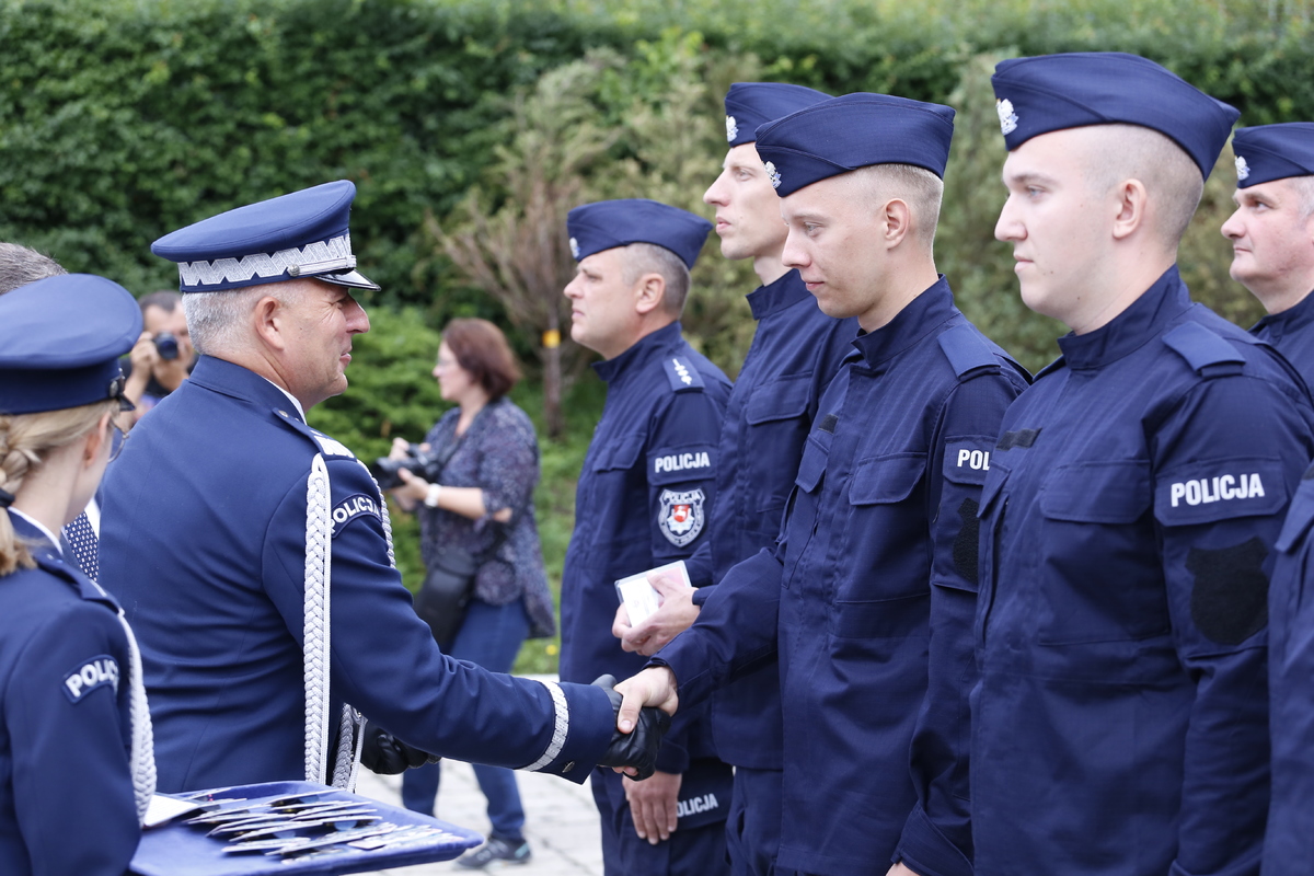 Komendant Wojewódzki Policji w Lublinie nadinspektor Artur Bielecki wręcza legitymacje nowemu policjantowi.