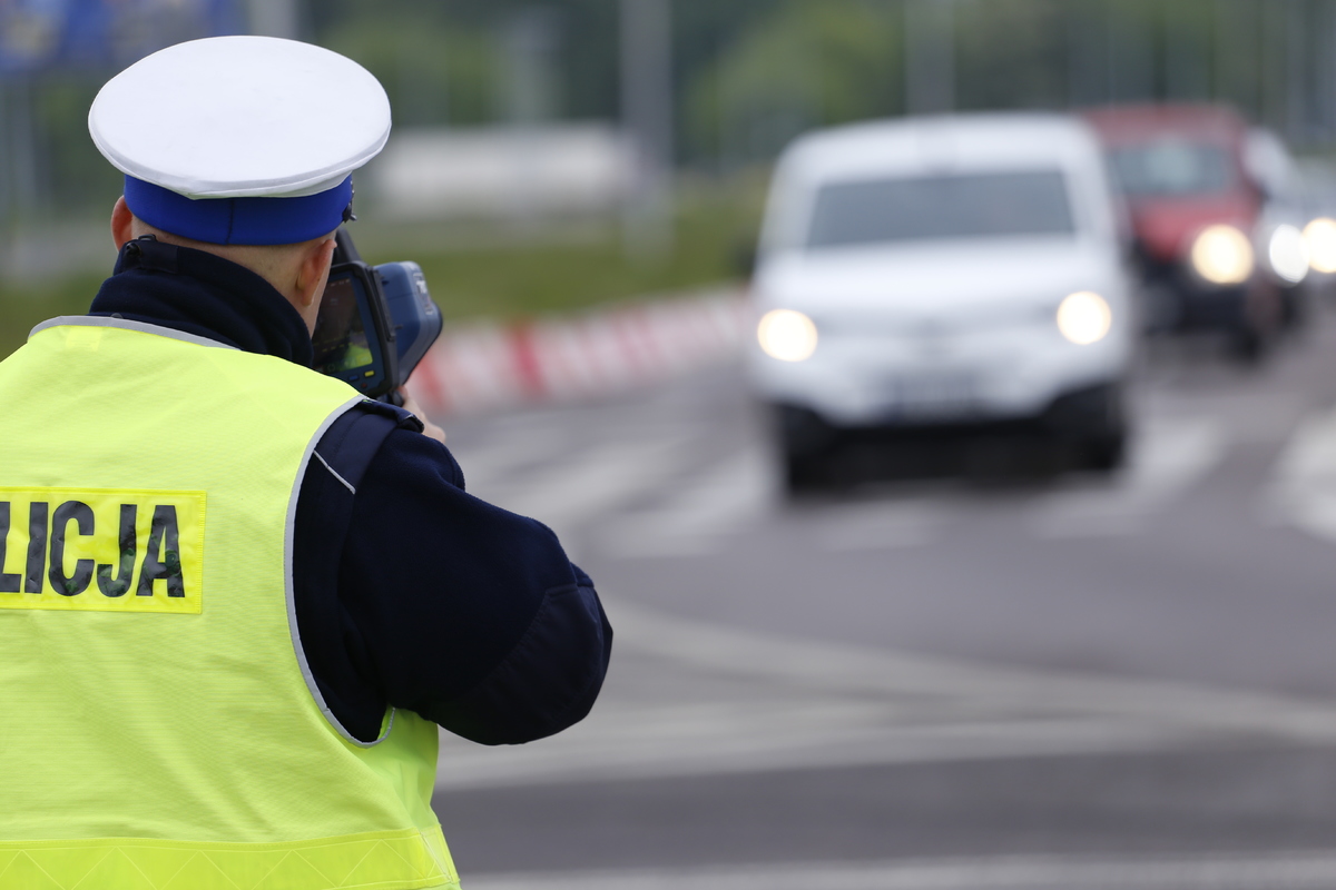 policjant dokonuje pomiaru prędkości jadącego pojazdu