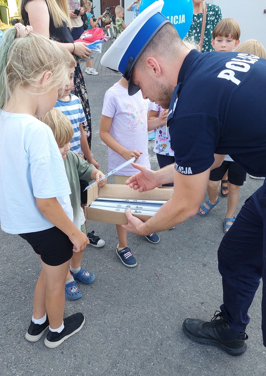 policjant rozdaje dzieciom odblaski