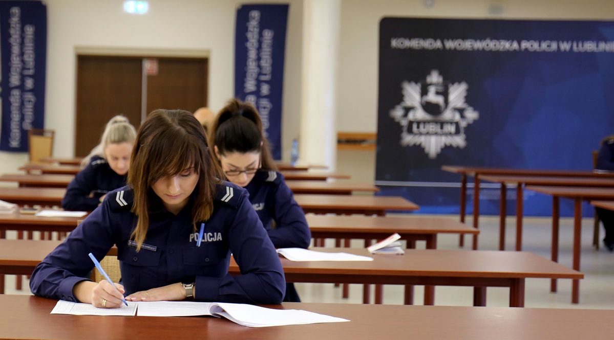 policjanci podczas pisania testu na sali konferencyjnej