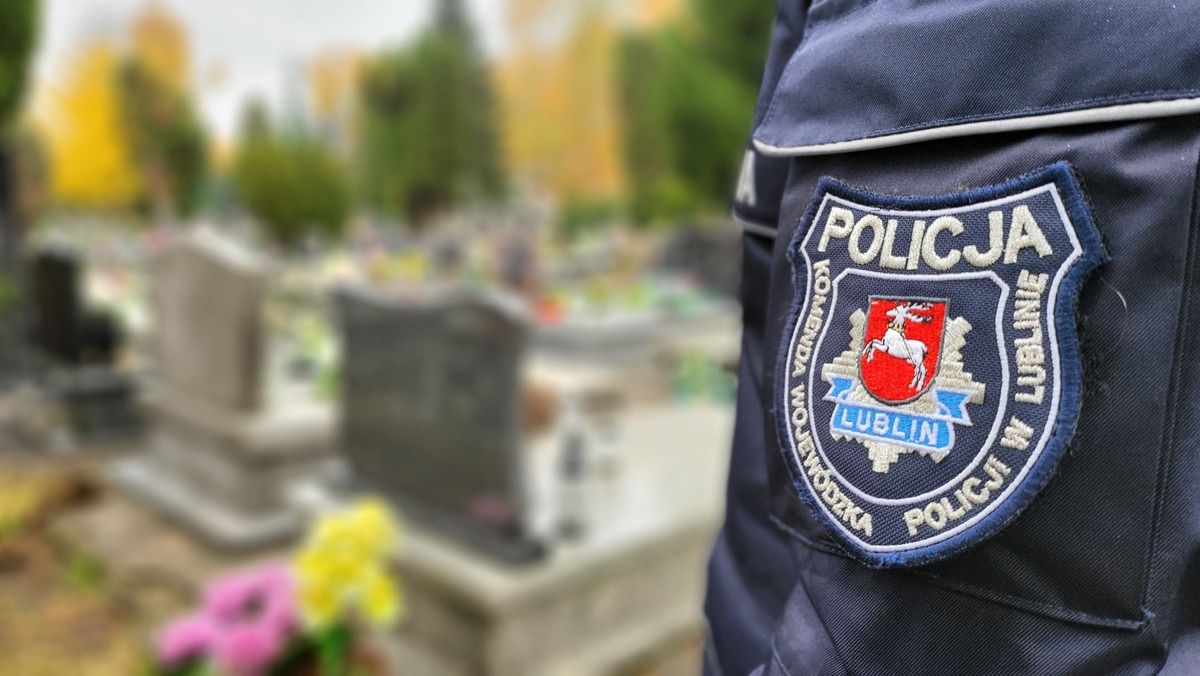 Naszywka Komendy Wojewódzkiej Policji w Lublinie na tle cmentarza w Lublinie.