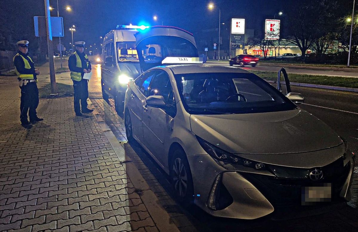 Policjanci kontrolują taksówkę na aplikację.