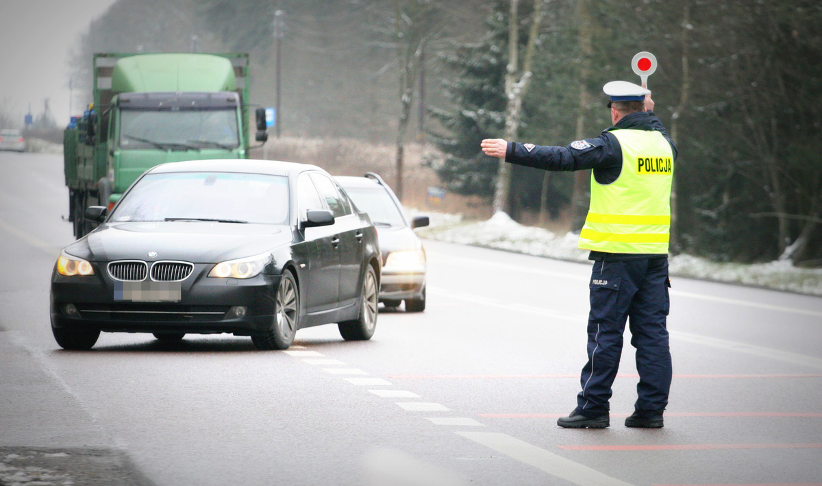 Policjant zatrzymuje pojazd do kontroli.