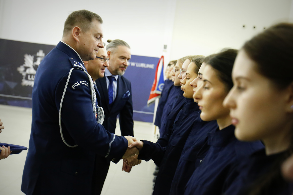 Komendant Wojewódzki Policji w Lublinie wręcza legitymacje służbową nowemu policjantowi.