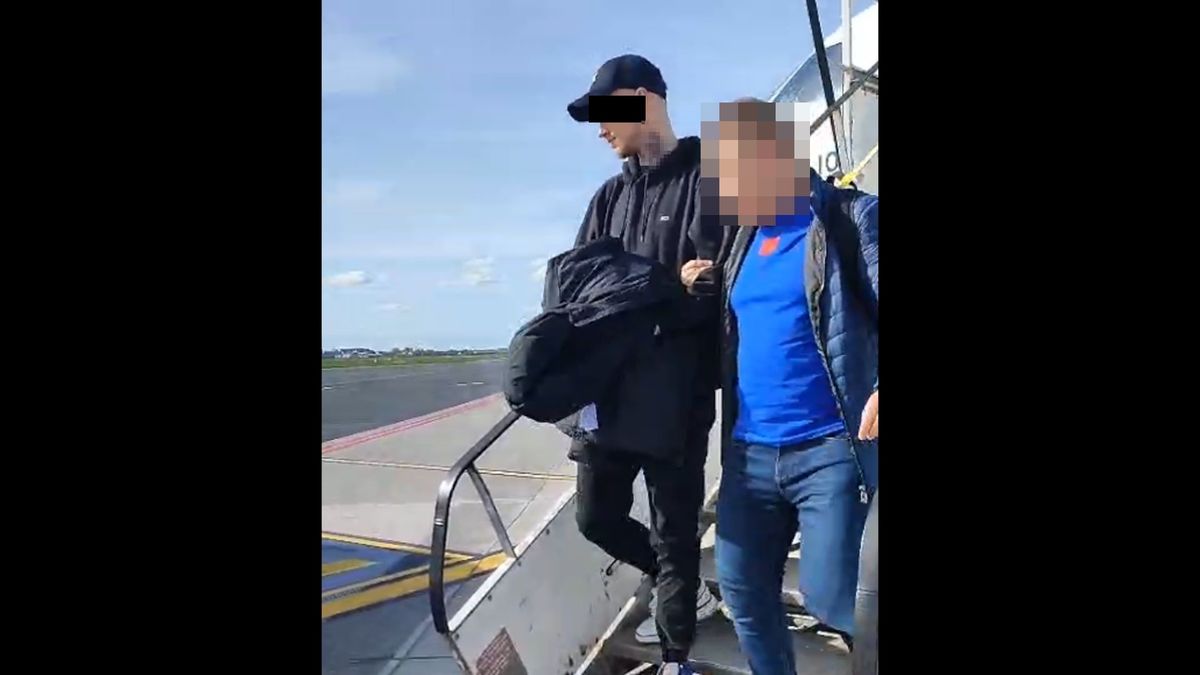 policjanci prowadzą zatrzymanego mężczyznę z samolotu