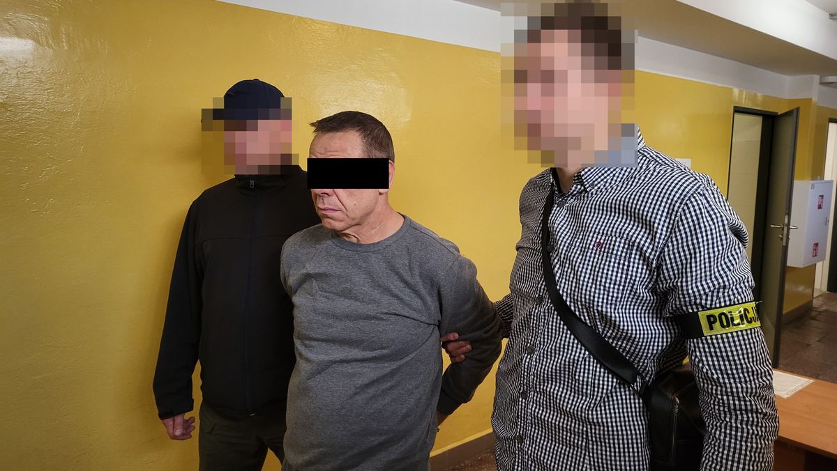 Policjanci prowadzą zatrzymanego mężczyznę.